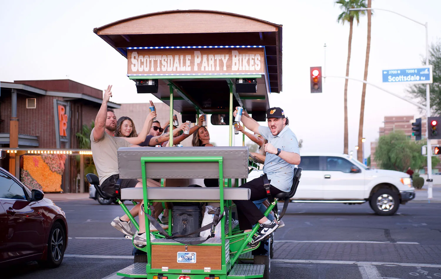 group on scottsdale party bikes lifting up their drinks in the air